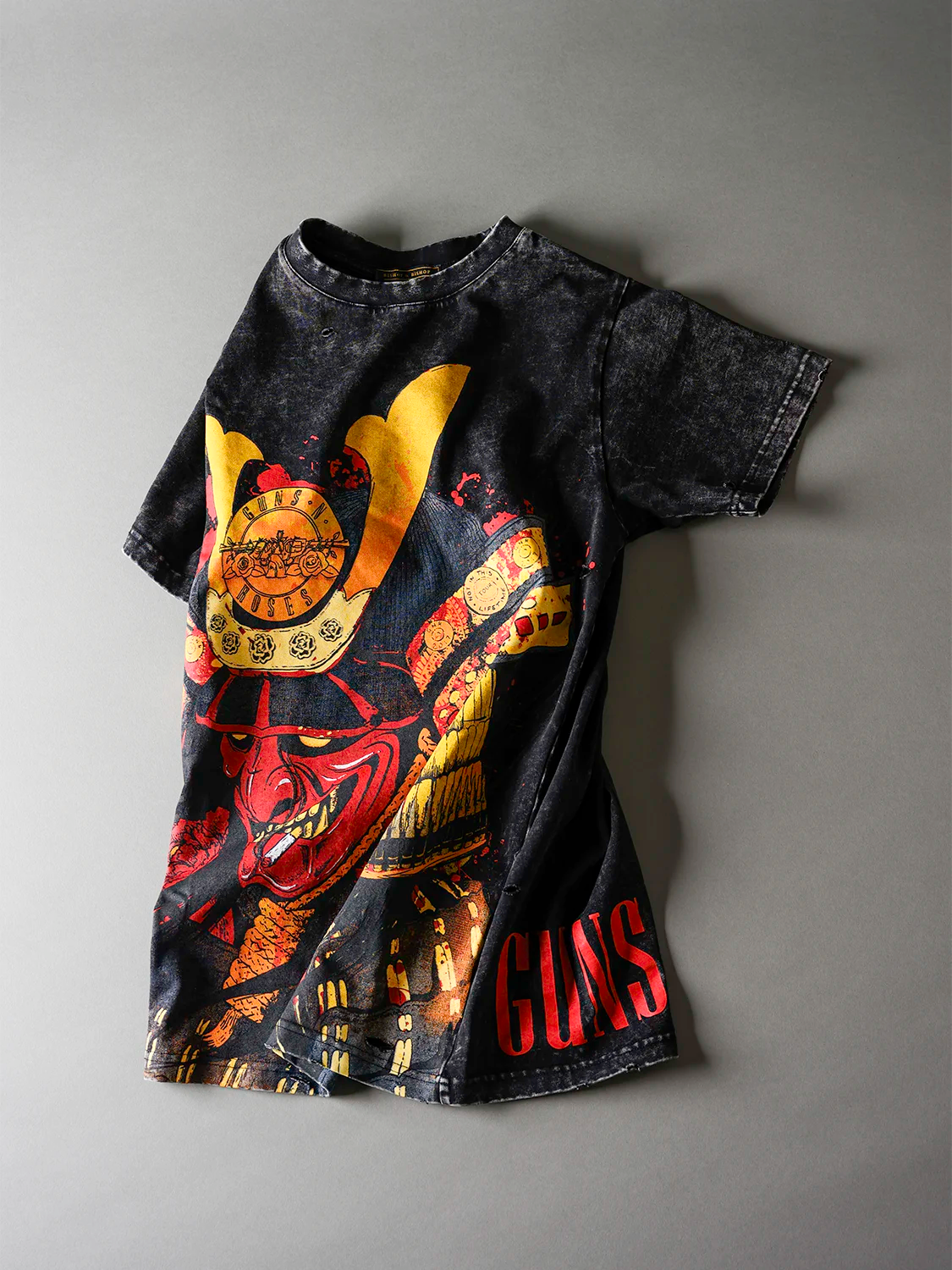 Black t-shirt with colorful graphic design on a gray background