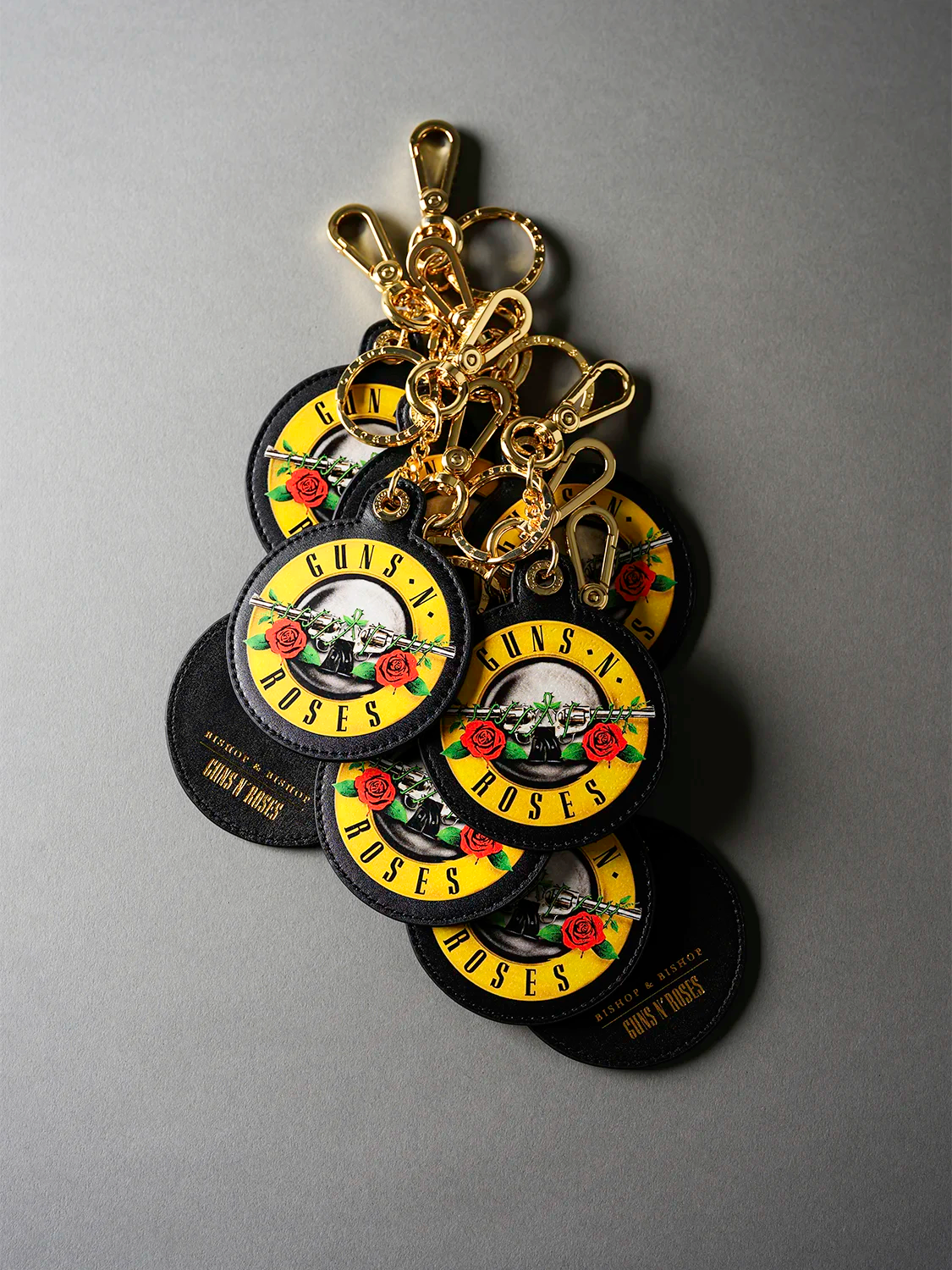 Collection of 'Guns N' Roses' branded keychains on a gray background