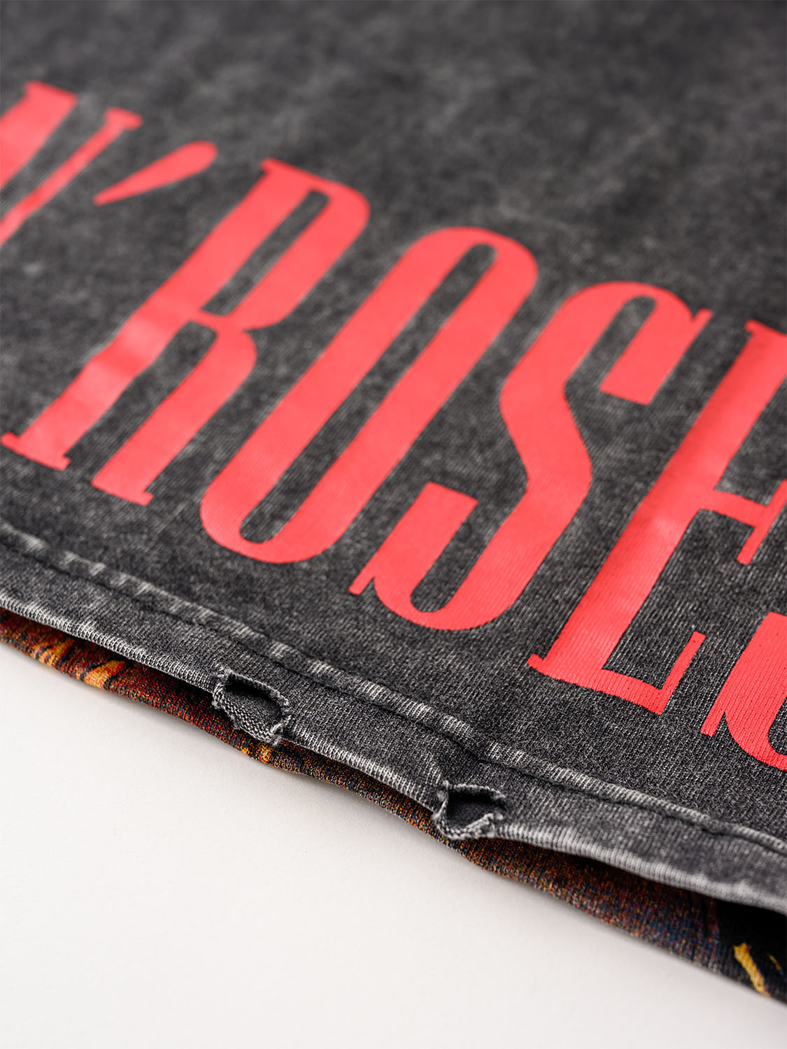 Close-up of a black t-shirt with 'Guns N' Roses' text on a white background