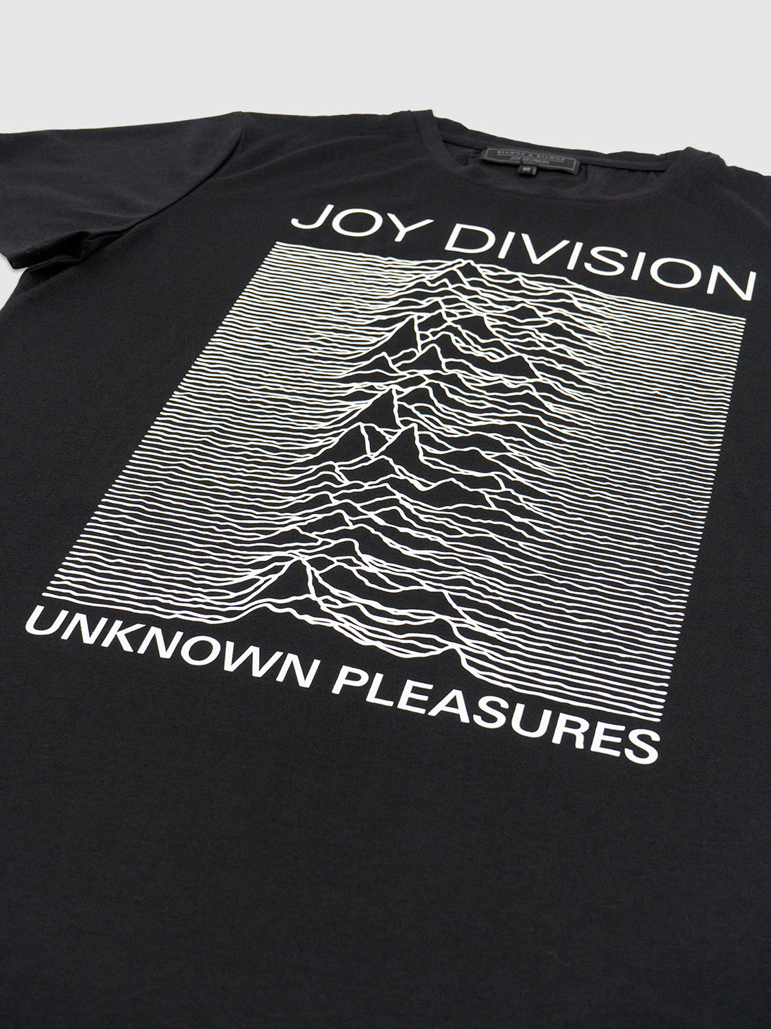 Angled close-up of the chest print showing the fine detailing of the Unknown Pleasures waveform.