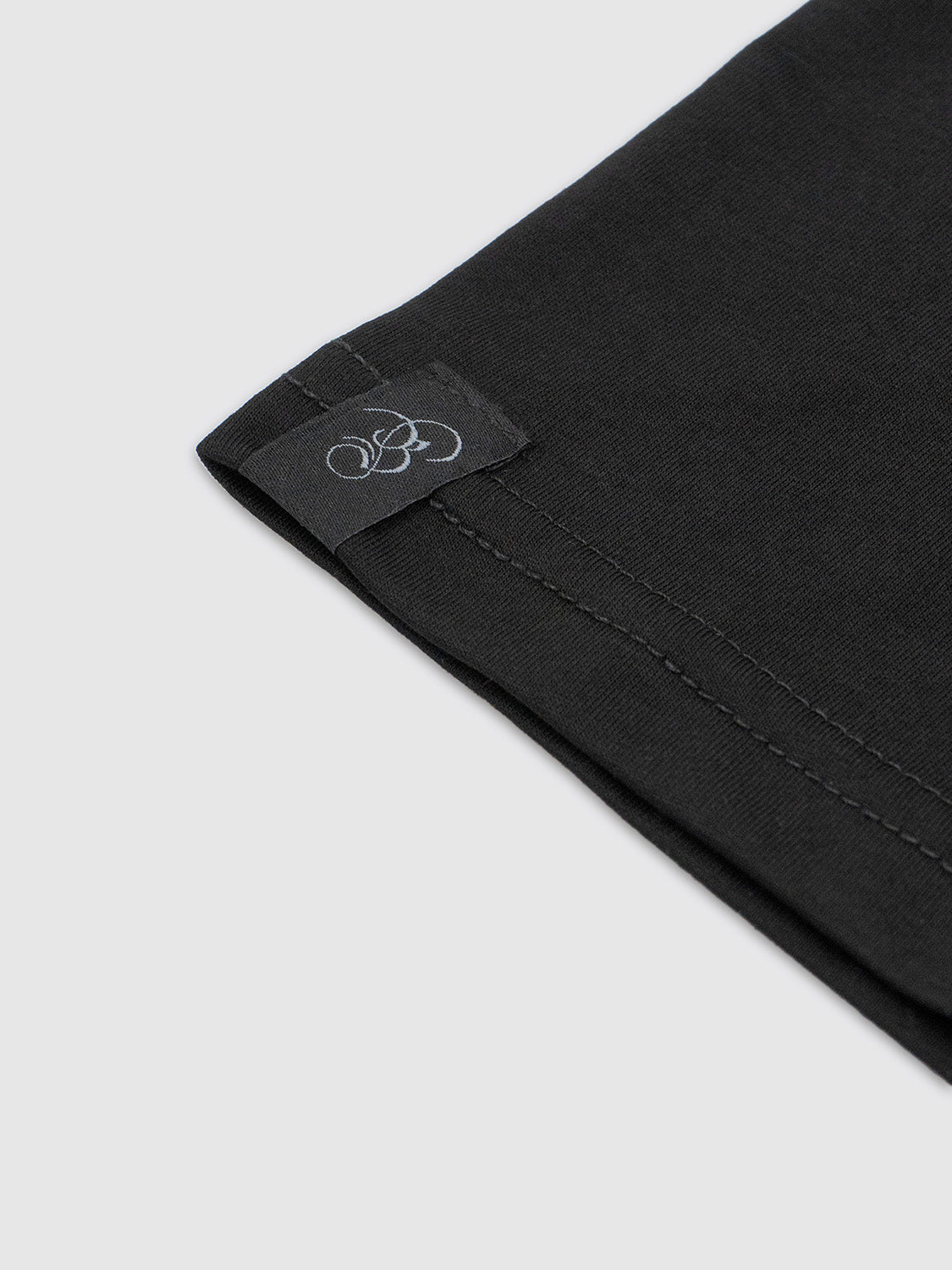 Macro view of the hem tag stitched near the bottom edge with Bishop & Bishop branding.
